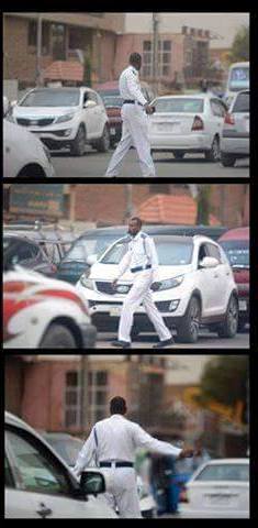 بالصور.. وفي لفتة بارعة.. ضابط بشرطة المرور السودانية يستأذن أسرته وينزل من سيارته لينظم حركة المرور وهو يمازح السائقين (يلا يا حاج حرك عشان تحصل الفطور .. ويا عمو هدئ أدي الخالة دي فرصة عشان تعدي) 2 ضابط2_n