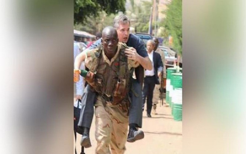 جندي مالي يحمل سائحا على ظهره