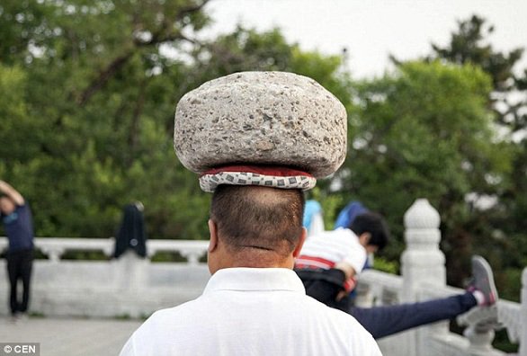 صيني يحمل حجراً على رأسه ليخسر الوزن الزائد1