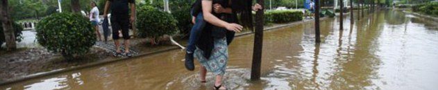 مقتل 10 أشخاص بانزلاقات تربة وفيضانات 10 صينية تحمل خطيبها على ظهرها لعبور مياه الفيضان