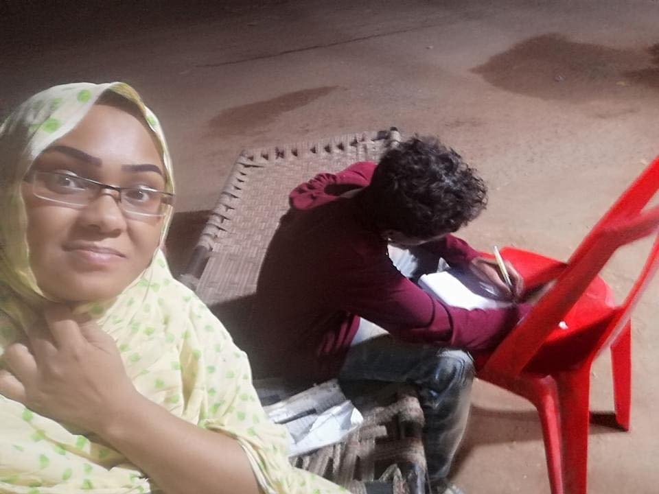 قطوعات الكهرباء تدفع أم سودانية لاصطحاب ابنها الطالب للمذاكرة تحت أضواء بقالة2
