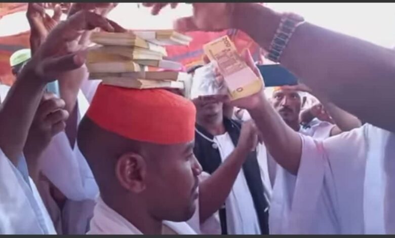 شاهد بالصورة والفيديو.. في تقليعة جديدة وبدلاً من النقطة.. رجل سوداني ثري يرص حزم من الأموال على رأس صديقه العريس ومتابعون: (رأس العريس أصبح كالبنيان بالمال بدلا من الطوب) 1 رص المال
