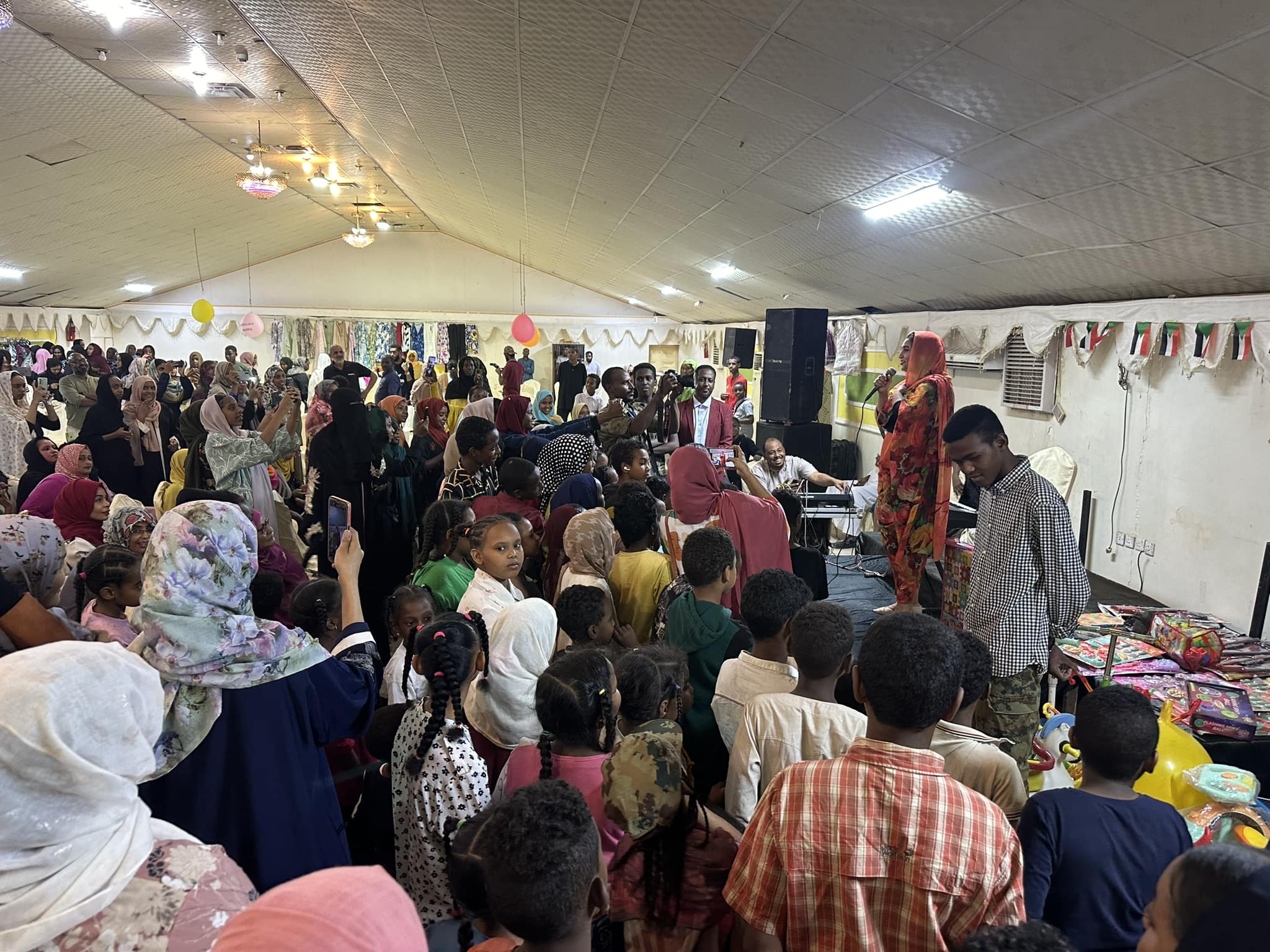 شاهد بالصورة والفيديو.. الفرحة تعود لأمدر.. إقامة أضخم "بازار" بإحدى صالات الأفراح بأم درمان بحضور الآلاف من المواطنين ومطرب الحفل يشعل القاعة بالأغاني الحماسية 10 433926720 7586522424733766 1278286414315319279 n