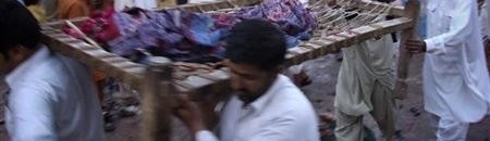 مشيعون يحملون أشلاء أحد ضحايا انفجار عند ضريح صوفي في شرق باكستان يوم الأحد 3-4-2011 10 913